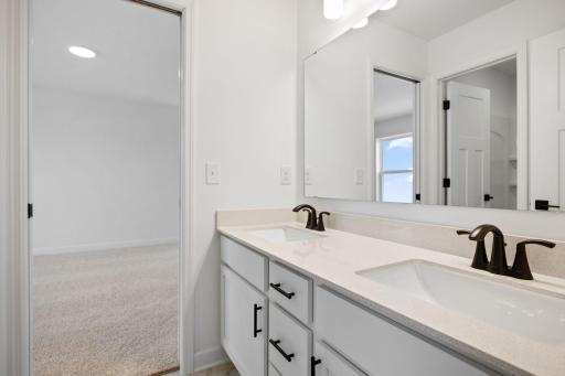 (Photo of a similar home, actual finishes may vary) This Jack-and-Jill bathroom connects two bedrooms on the second floor, with dual sinks to accommodate shared living.