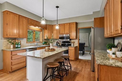 The eat-in kitchen offers a center island, granite countertops, stainless steel appliances, and plenty of space for everyday dining.