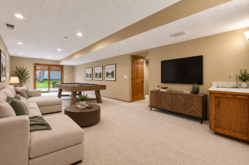 The lower level provides even more space to relax and entertain, featuring a family room, game area, versatile flex room, guest bedroom, and three-quarter bathroom. Photo has been digitally staged.