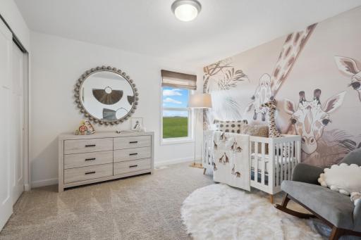 (Photo of a decorated model, actual homes finishes will vary) One of the spacious secondary bedrooms on the upper level.