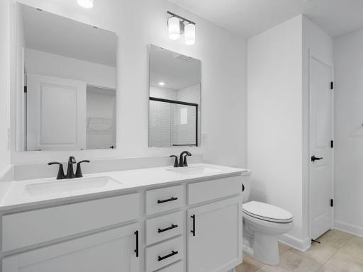 Easily balance shared routines at the elegant dual-sink vanity topped with twin plate glass mirrors