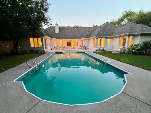 The pool transitions between the more formal tiled patio in the background to the flat, private back yard in the foreground shaded by mature trees. Pool has new filtration system. Seller is in the process of replacing the pool liner.