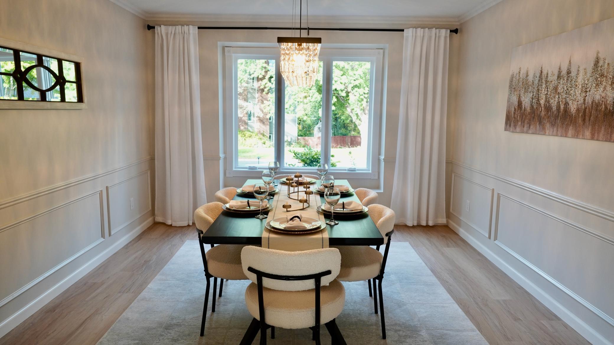 The large formal dining room has several features that set this room apart including a large bay window, decorative wainscoting and a gorgeous crystal chandelier.