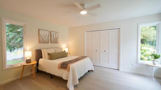 Bedroom 5 is filled with natural light from two sides, has views of the patio and pool area, and an oversized closet with a brand new closet system. It also features a new ceiling fan, carpet and fresh paint.