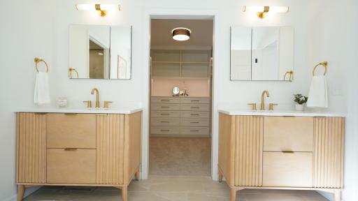 The separate, designer vanities and large medicine cabinets flank an oversized walk-in closet with custom cabinetry that includes subtle, indirect lighting.