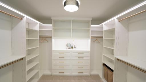 Minimize your need for dressers with this versitile, highly customized primary bedroom closet system which features integrated indirect lighting, two clothes hampers, and a wide array of drawers, hanging areas, and open storage.