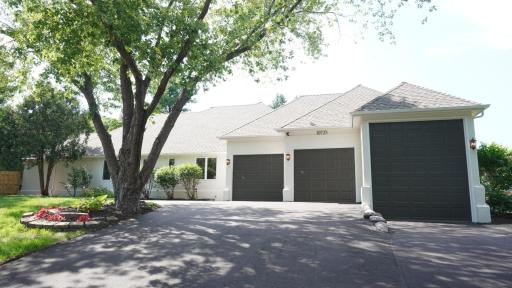 The staggered garage doors add visual interest to the facade facing the cul-de-sac. The third garage stall is wider and taller for a boat, RV or car lift. The large driveway has been newly paved, and new lights flank the freshly painted garage doors.