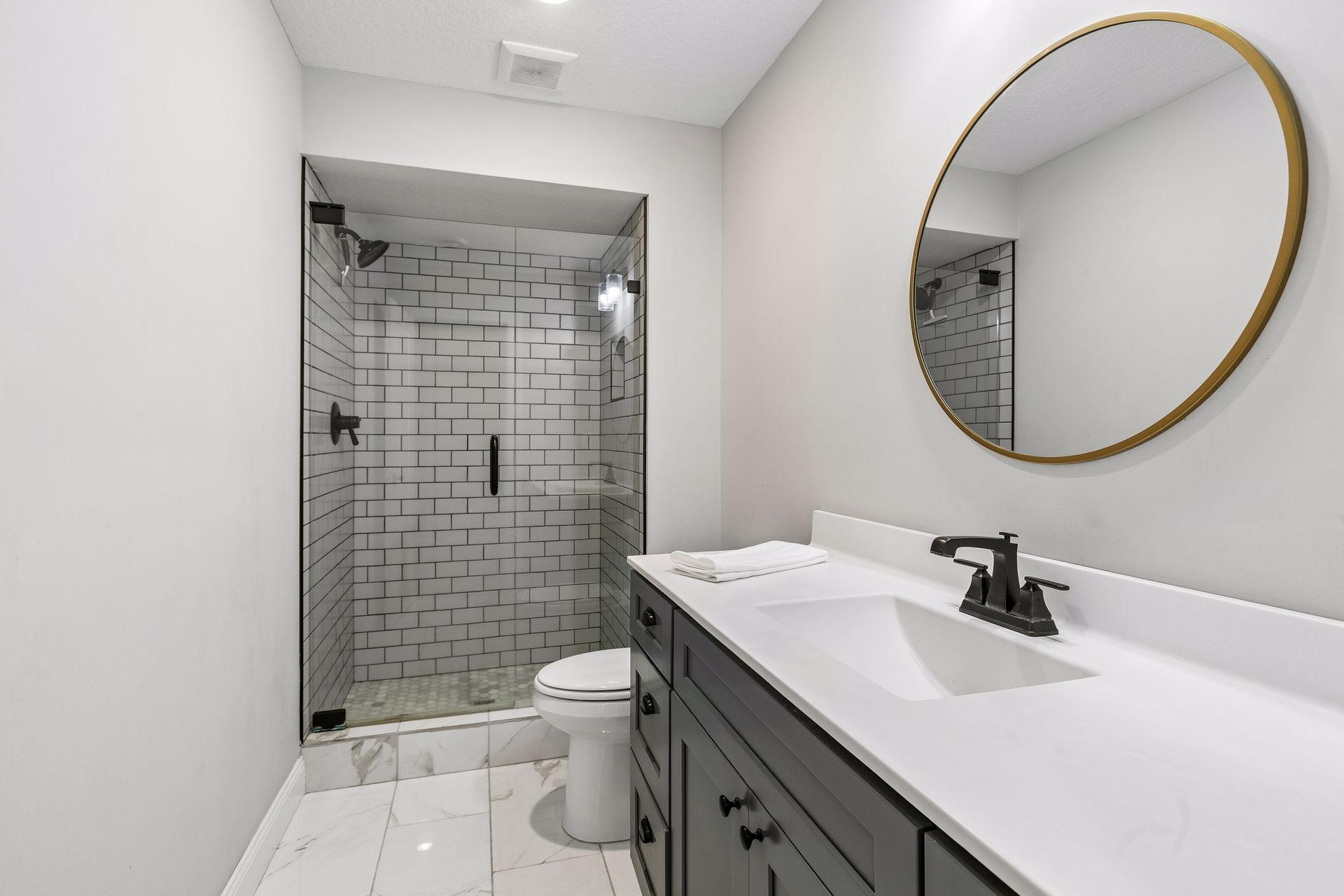 Convenient lower-level bath near the fifth bedroom and entertaining spaces.