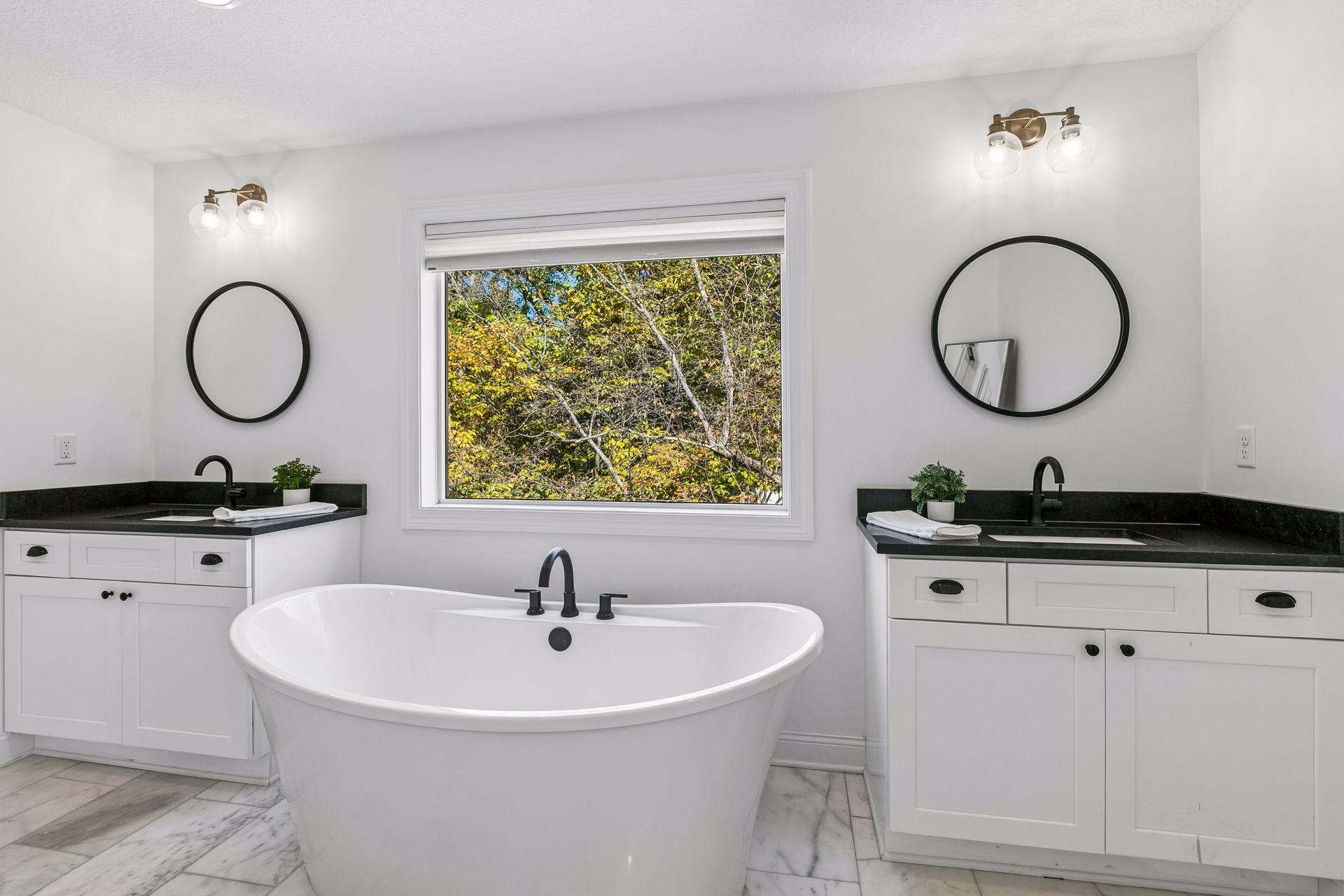Primary bath features double vanities, a tub and abundant natural light.