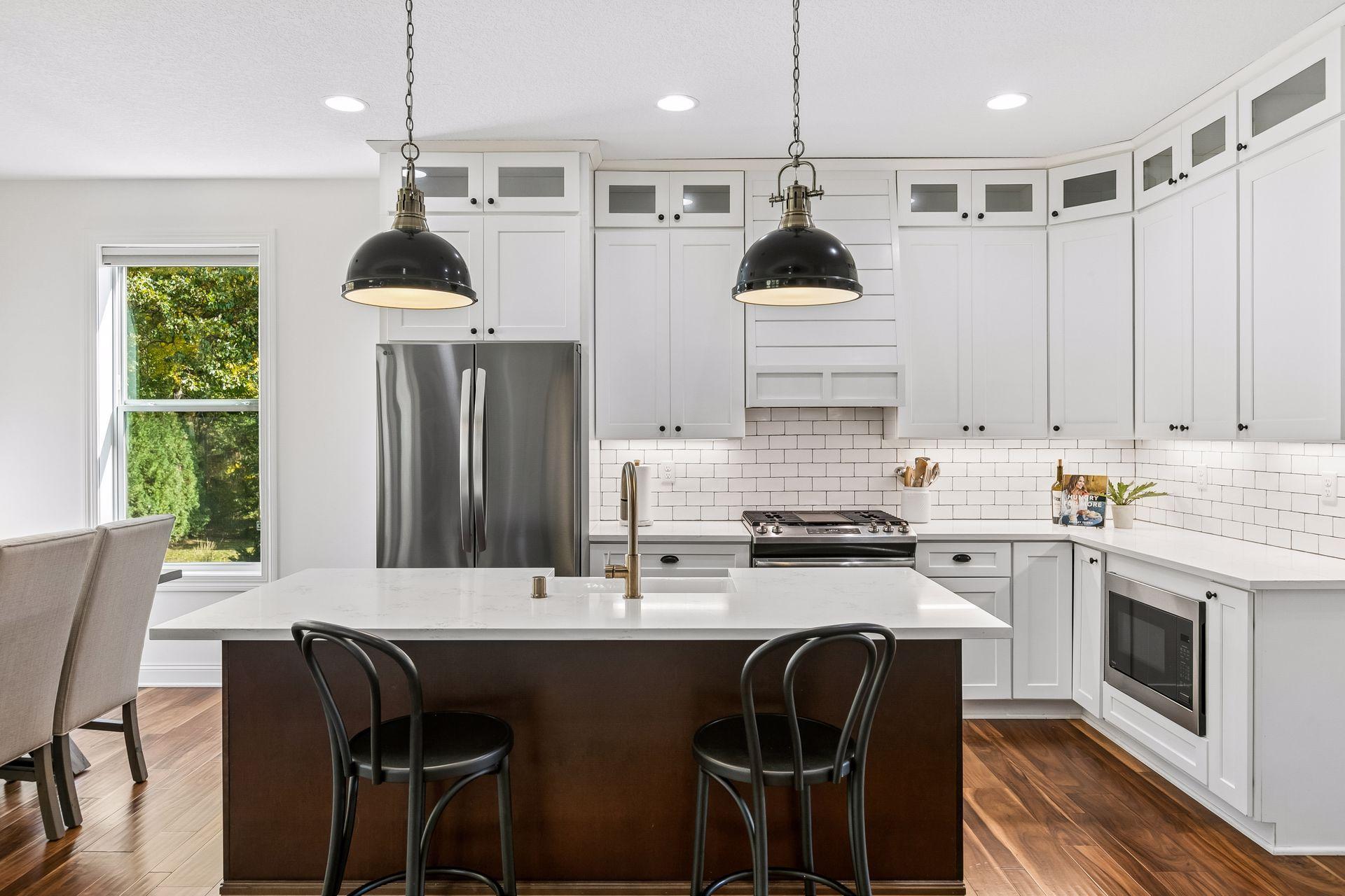 Beautiful white kitchen complemented by stainless steel appliances.
