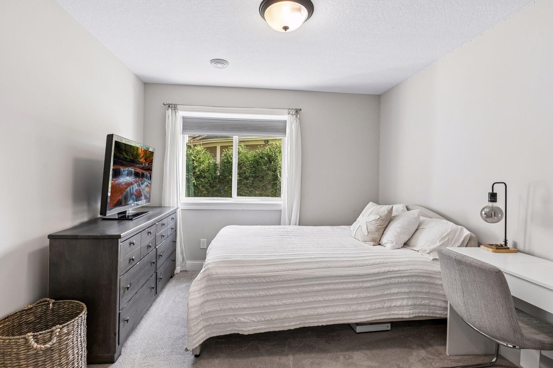 Fifth bedroom located on the lower level offers a comfortable space for guests.