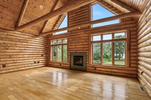 Breathtaking two-story great room features soaring tongue-and-groove ceilings, massive exposed beams, a cozy gas fireplace and a dramatic wall of windows framing beautiful views of Otter Lake.