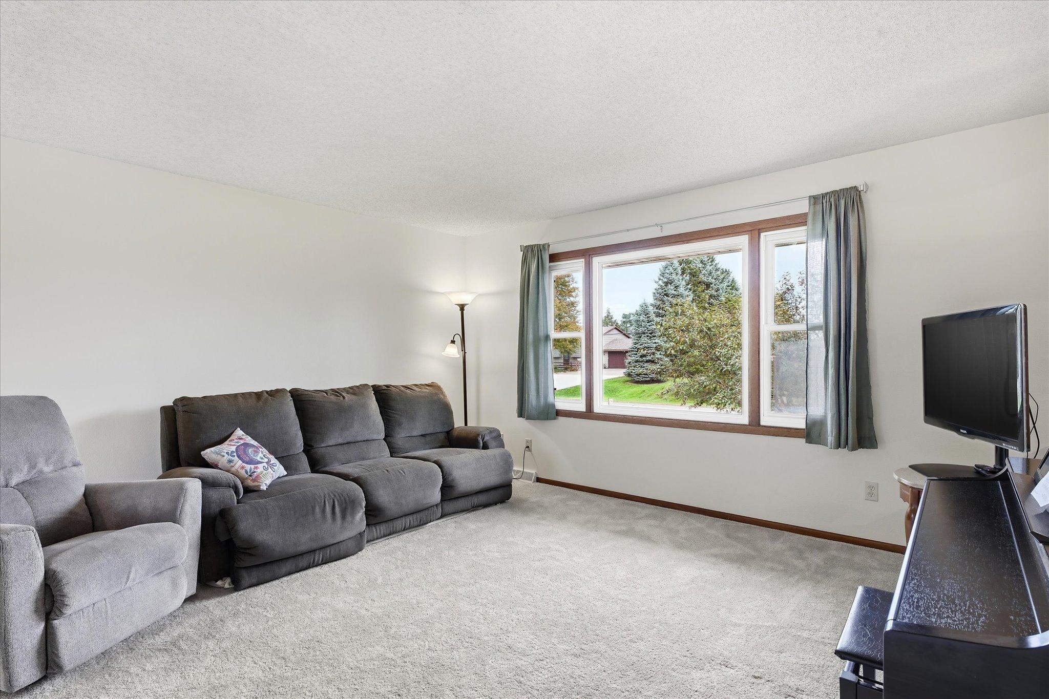 Bright and spacious living room has plenty of room for a large entertainment setup with multiple seating options.