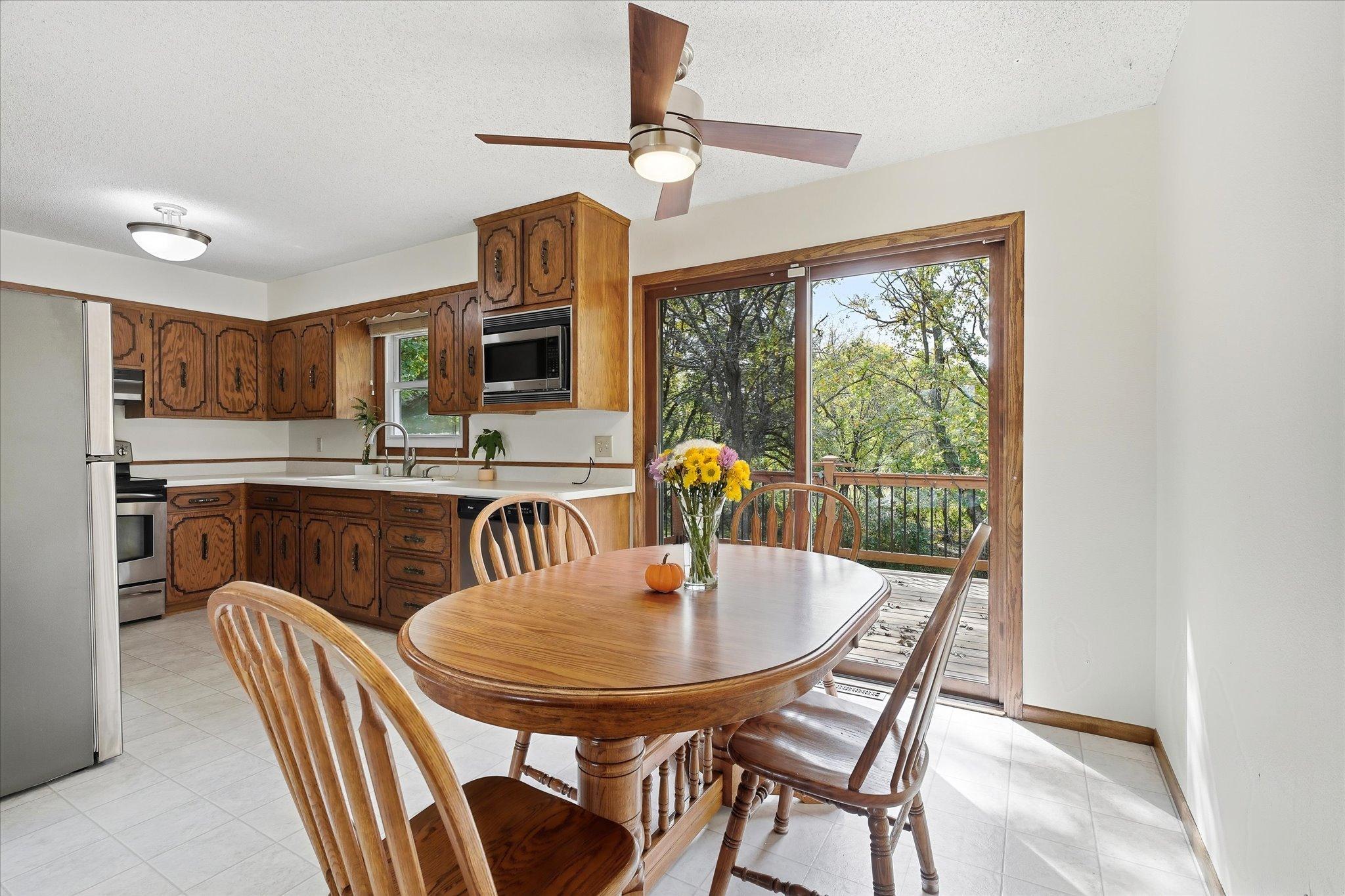 Informal dining area conveniently located off the kitchen, featuring a ceiling fan and sliding glass door to the deck, where you can enjoy peaceful nature views while dining.