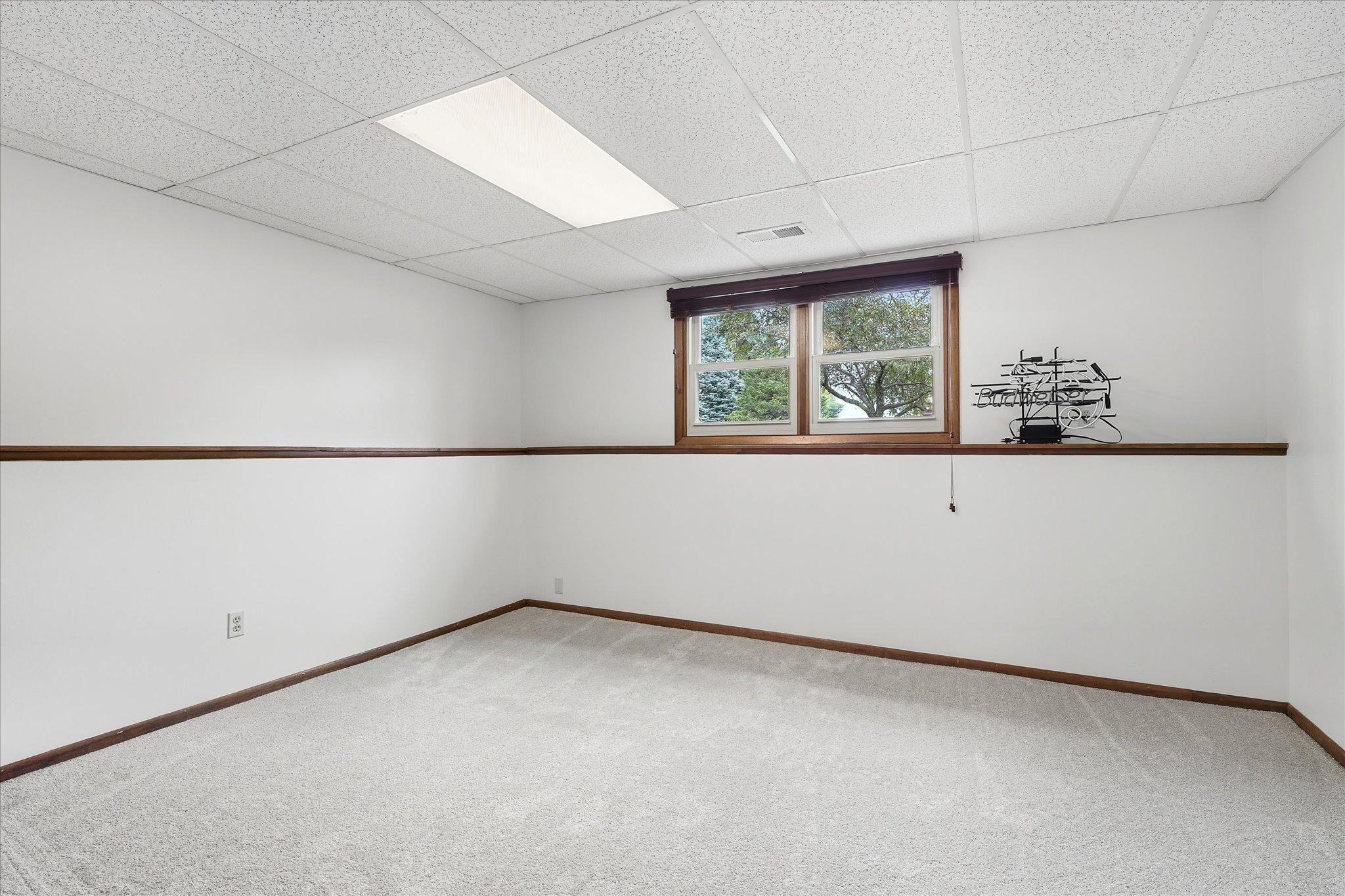 Spacious lower-level family room with a continuous display ledge that adds character and provides the perfect spot for décor, photos, or collectibles.