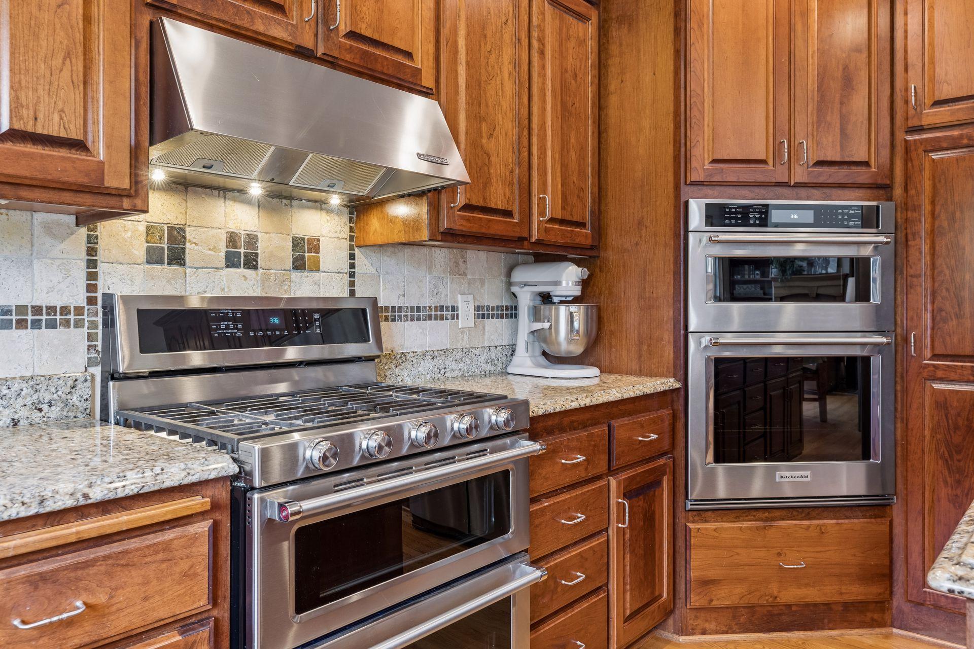 The Kitchen is equipped with new KitchenAid appliances including a gas range with a double oven, built-in wall oven and convection microwave oven.