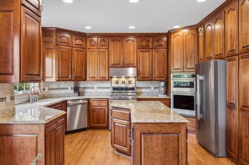 Extensive custom cabinetry provides ample space for storage and organization. The pantry cabinetry features roll-out shelving for ease.