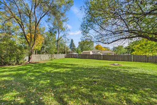 Large, level backyard enclosed by a secure privacy fence.