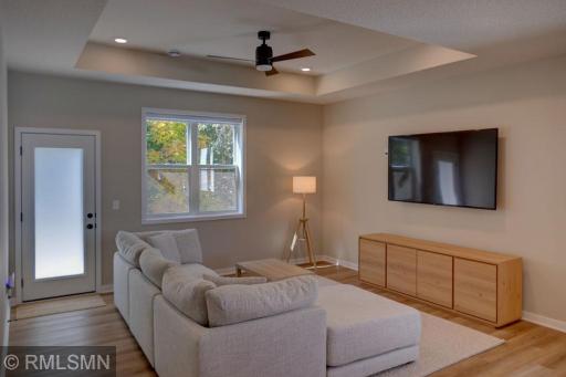 Living room with a tray ceiling and a view of the private backyard.