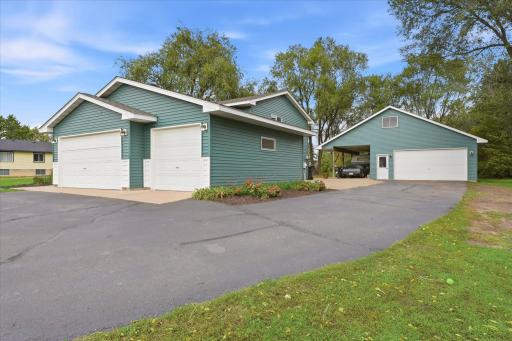 Exceptional garage space includes an attached three-car garage plus a large detached garage with an additional covered area, ideal for vehicles, recreational equipment, hobbies, or extra storage.
