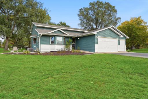 Spacious yard surrounds the home, with a convenient patio area just off the side of the home.