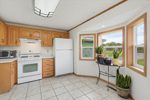 A gas range, ample cabinetry, and a charming window-lined nook overlooking the yard, perfect for a small breakfast table or additional seating area.