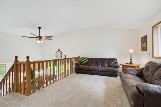 Spacious upper-level living room features new carpet, a vaulted ceiling and overlooks the dining area below, adding to the homeâs open, multi-level design.