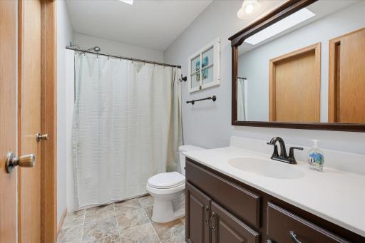Walk-through full bathroom is accessible from both the primary bedroom and hallway and features a large vanity, tub/shower combination and skylight.
