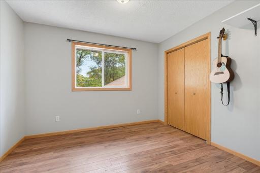 Upper-level bedroom features updated LVP flooring, neutral finishes, an updated window, and a spacious double closet.