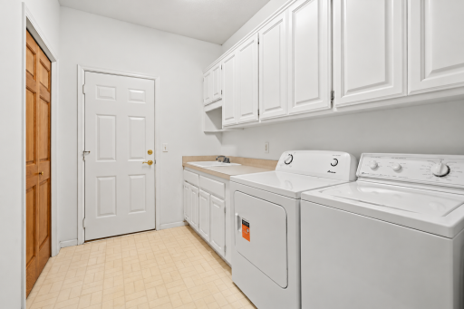 Spacious mudroom offering an abundance of storage and a convenient utility sink for added functionality!