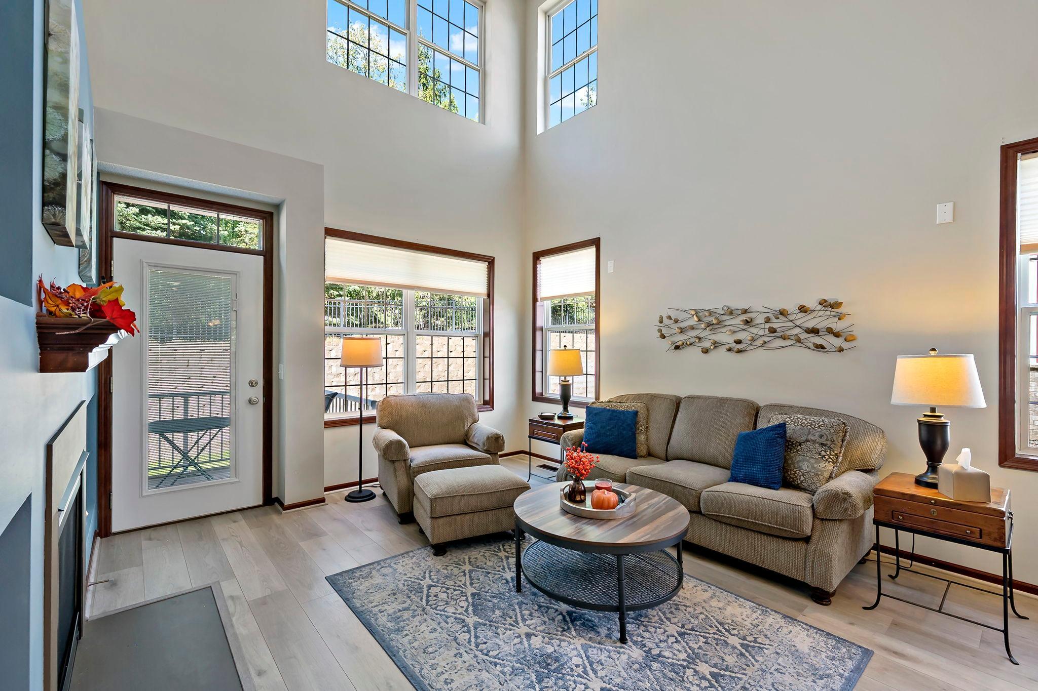 Comfortable living area surrounded by large windows overlooking the backyard.