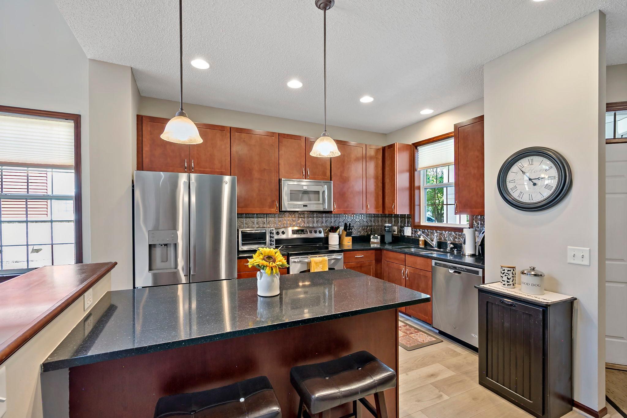 Updated kitchen with center island, granite countertops and stainless steel appliances.