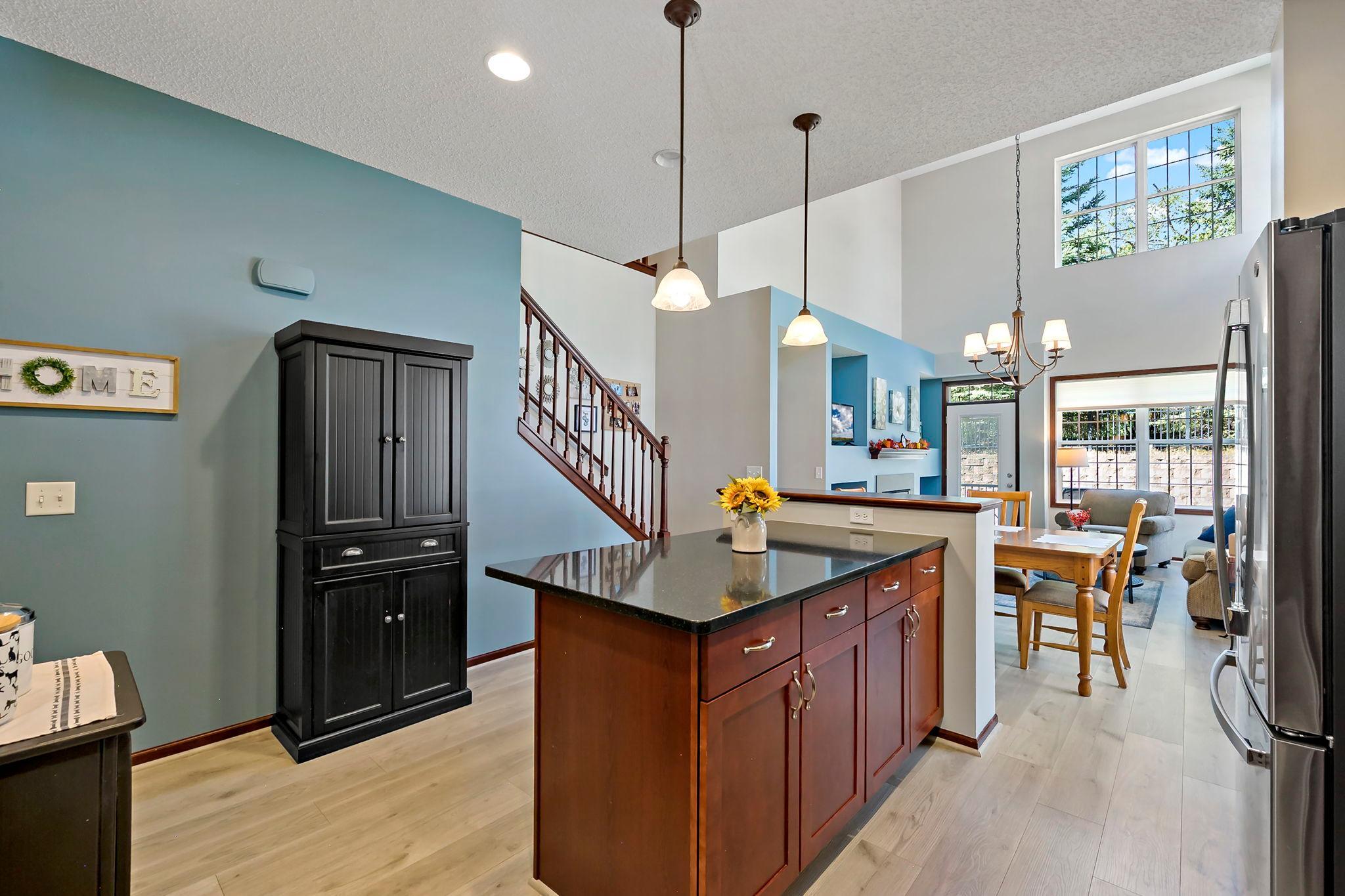 Two-story living space with fireplace, upper-level loft and open staircase.