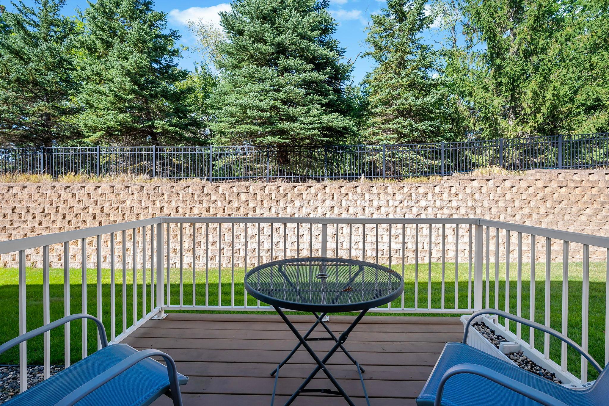 Private backyard setting with green space, mature trees and retaining wall.