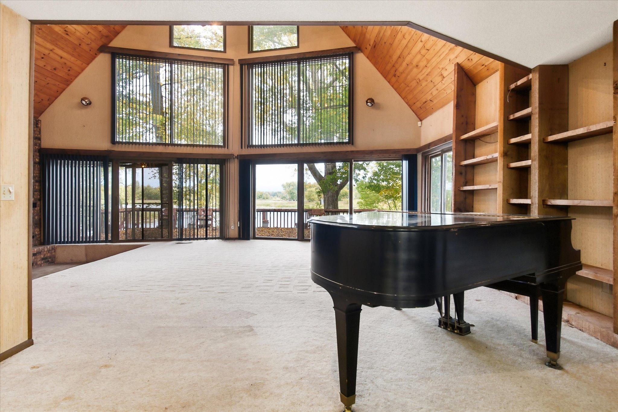 2+ story vaulted living room with wall of windows facing the river