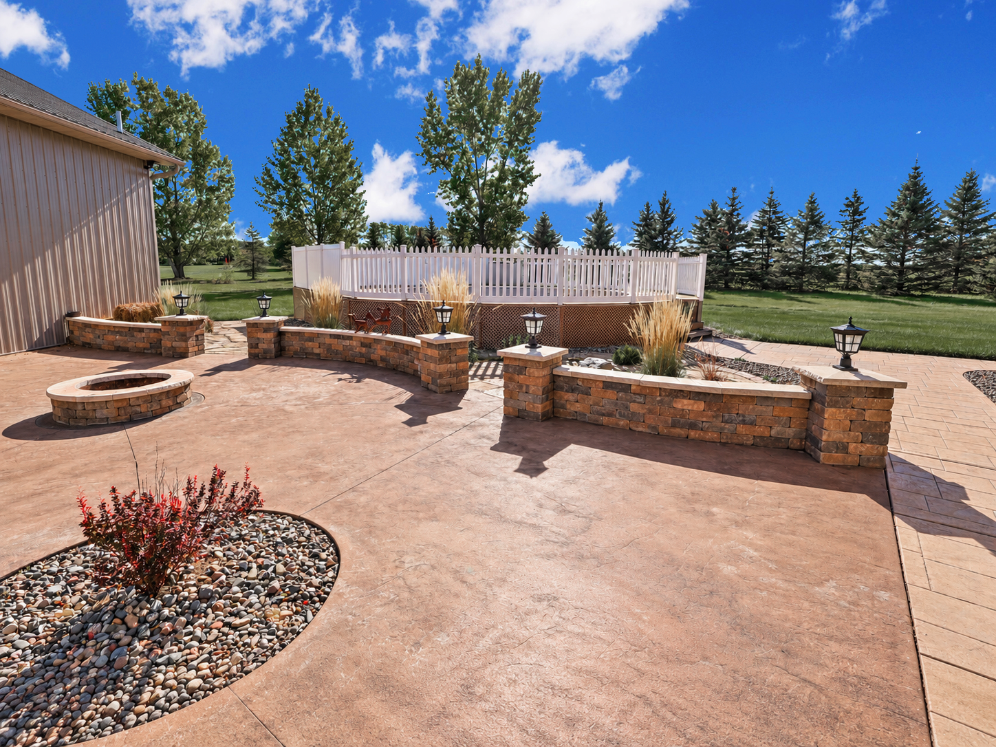 Beautiful colored stamped concrete and landscaped patio and firepit area.