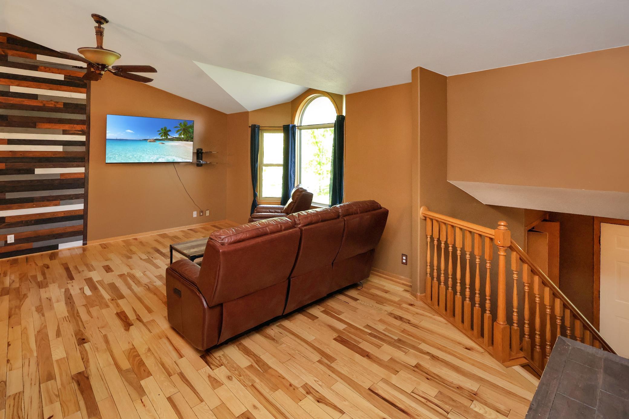 The vaulted ceilings and round top bay window accent the open living room.