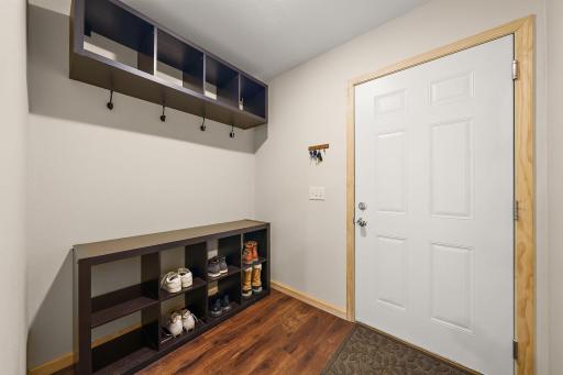 The mudroom is at the end of the hallway and the garage access door is on the right.