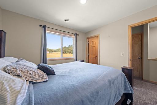 The second bedroom with the walk-in closet visible on the left and the door leading to the hallway and stair case on the right.