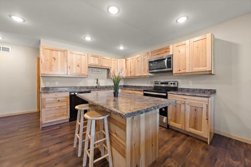 The kitchen features an island counter and has plenty of cabinet storage space!