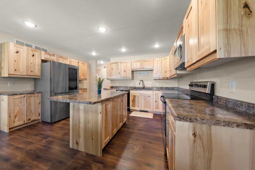 The kitchen has additional cabinets and counter space on either side of the refrigerator.