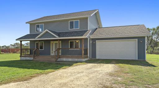 The front of the home features a porch perfect for relaxing and looking at the bluffs. The driveway is gravel with room for additional company to park when they visit.