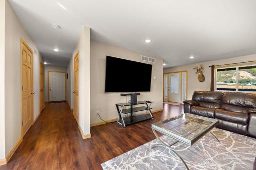 Standing by the backyard patio door and looking down the main floor hallway with the bathroom visible on the left and the door leading to the garage at the end of the hall.