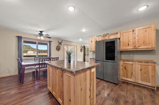 A view from the corner of the kitchen looking toward the dining area and front entry door of the home.
