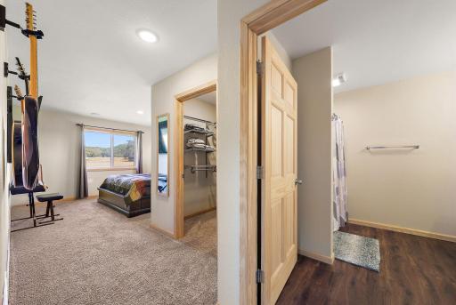 The primary bedroom has a en suite bathroom and a walk-in closet, both visible on the right as soon as you walk into the bedroom.