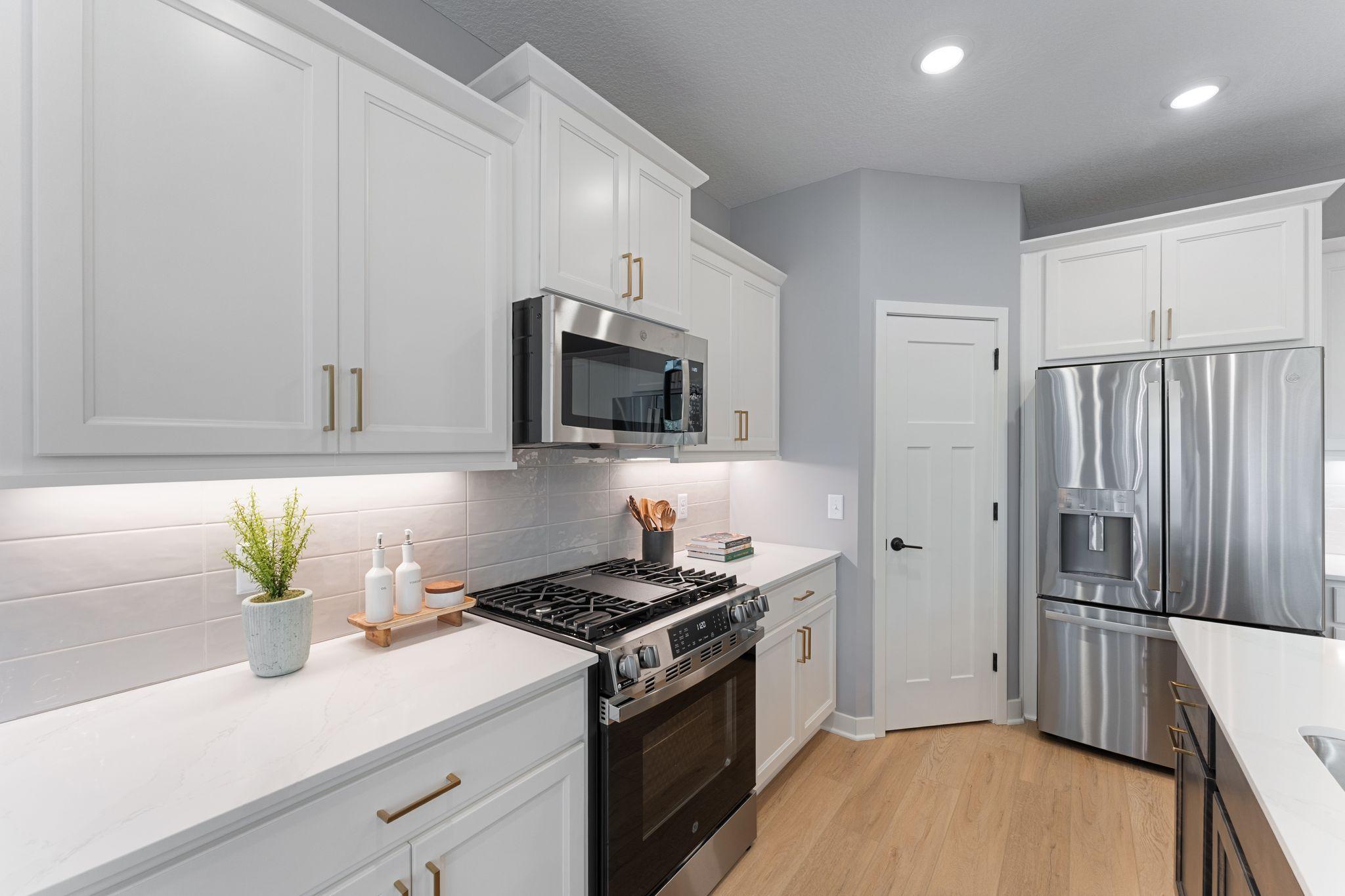 Step into a kitchen that blends clean finishes, smart storage, and plenty of space for everything from takeout nights to holiday hosting *photo of model home (design options may vary)