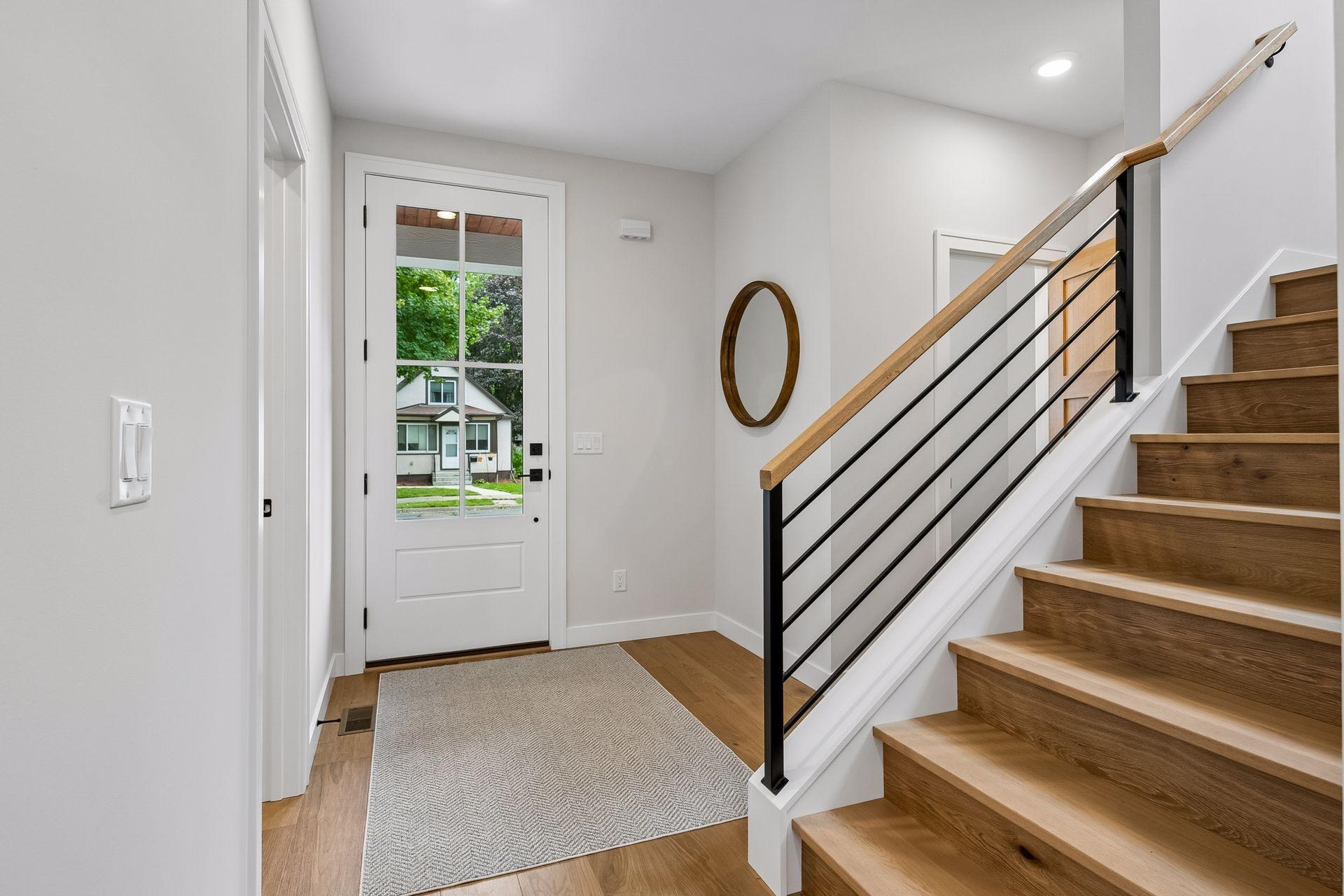 Open foyer with hardwood floors and hardwood staircase