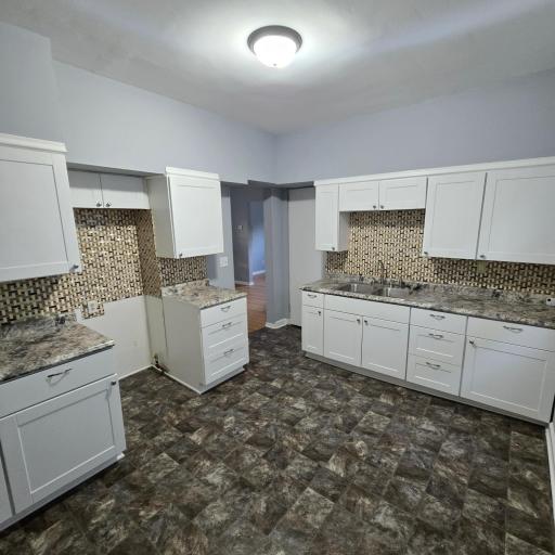 Brand new kitchen with tile backsplash (new range and refrigerator being installed).