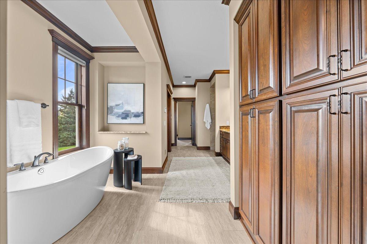 Freestanding soaking tub and linen closets.