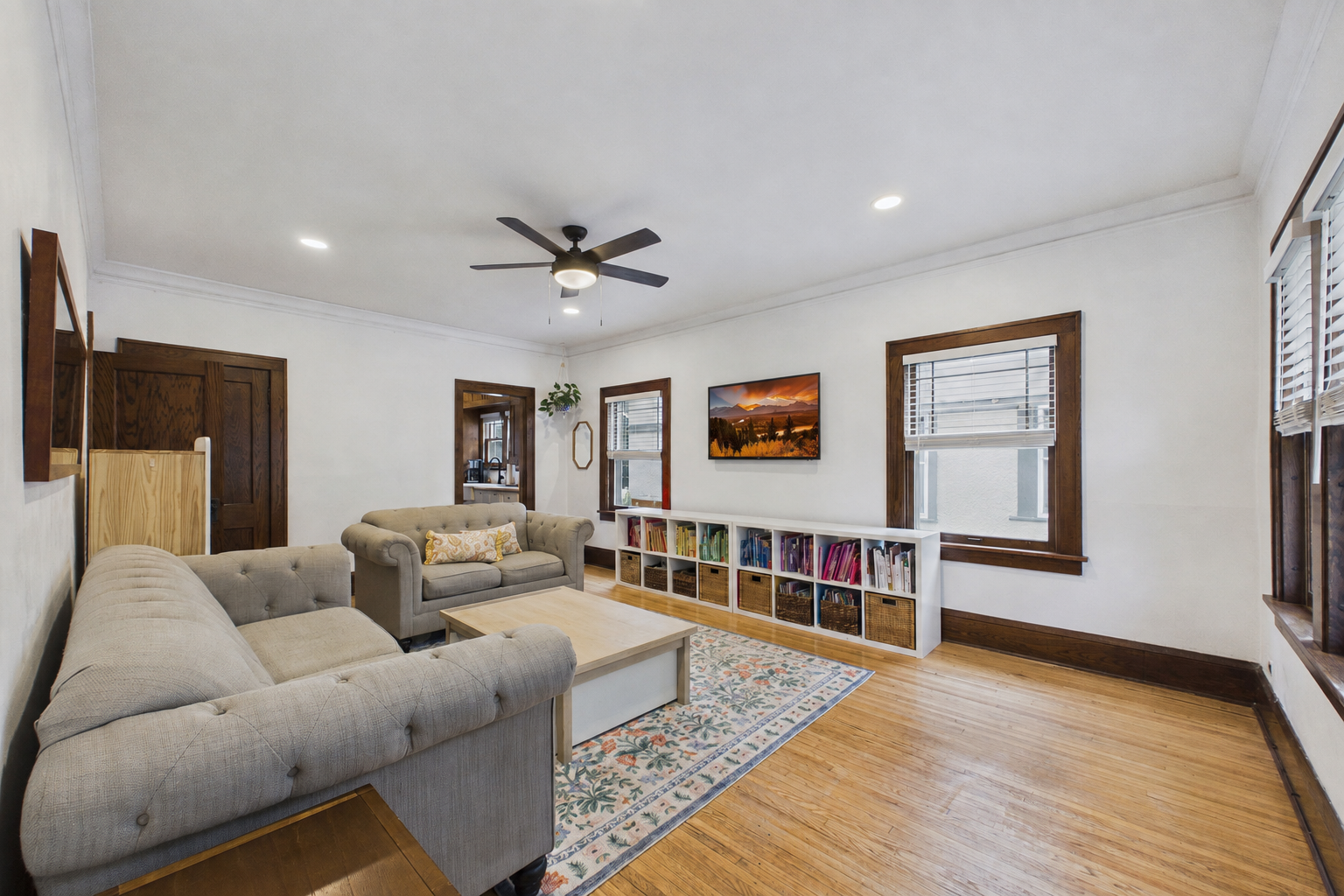 The family room is spacious and bright. There are recessed lights along with a ceiling fan.